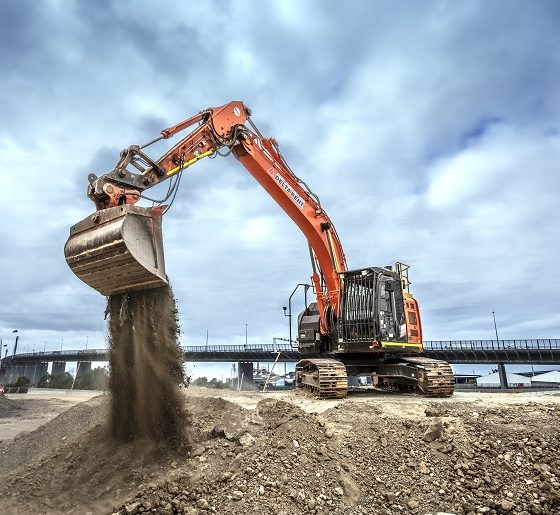 Orange excavator unloading debris